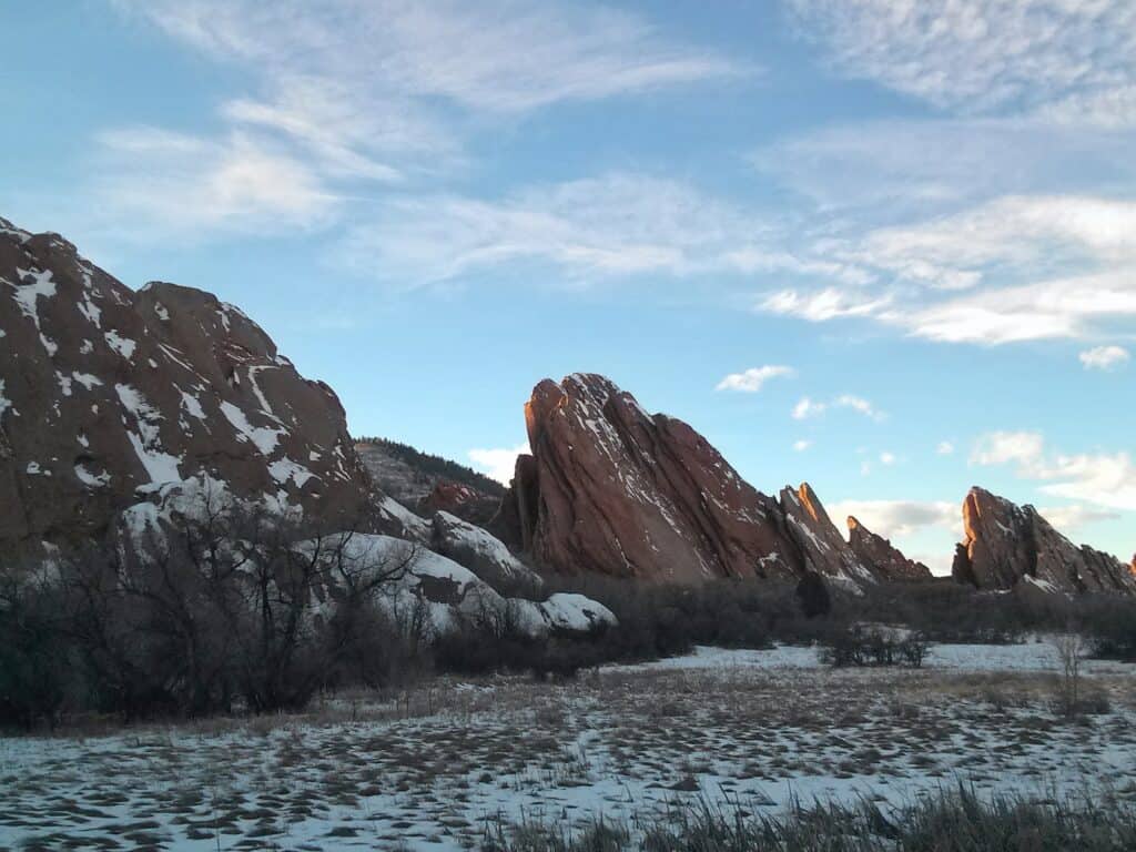 Red rock fins covered in snow along the Roxborough State Park Fountain Valley Loop Trail in Colorado.