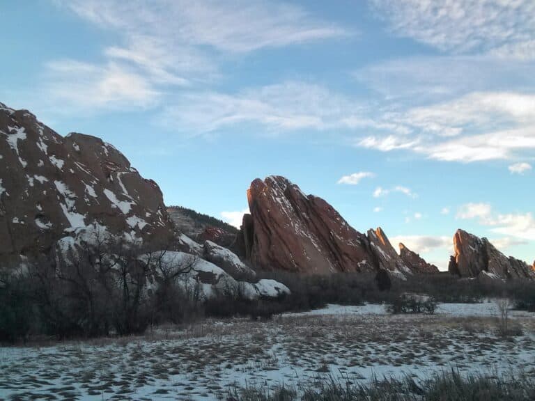 Red rock fins covered in snow along the Fountain Valley Loop Trail at Roxborough State Park in Colorado.