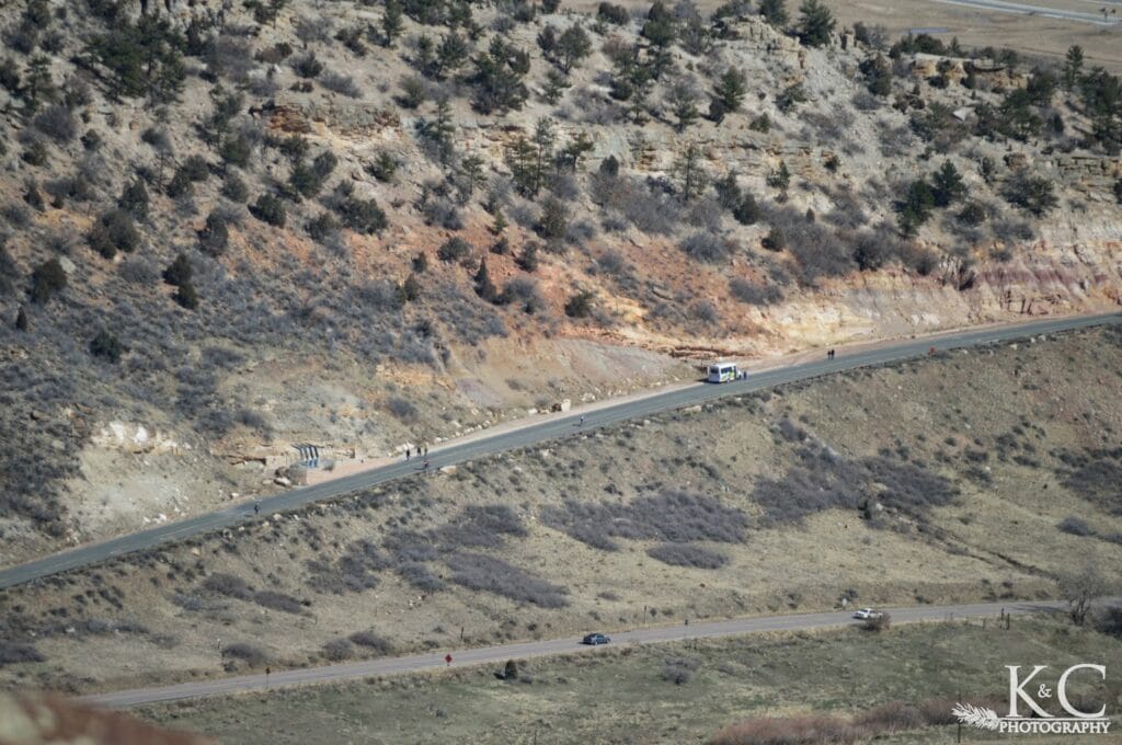 View of a shuttle bus and walking path along Dinosaur Ridge, adjacent to Matthews / Winters Park near Denver, Colorado. Visitors can hike or take the shuttle to see exposed dinosaur fossils and learn about the prehistoric history of the area.