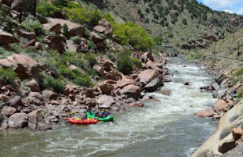 Red and green white water rafts on the Arkansas River in Royal Gorge.