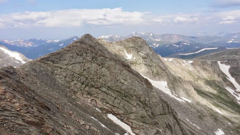 Mount Blue Sky, formerly Mount Evans, a Colorado mountain looms in the foreground with more Rocky Mountain peaks in the distance.