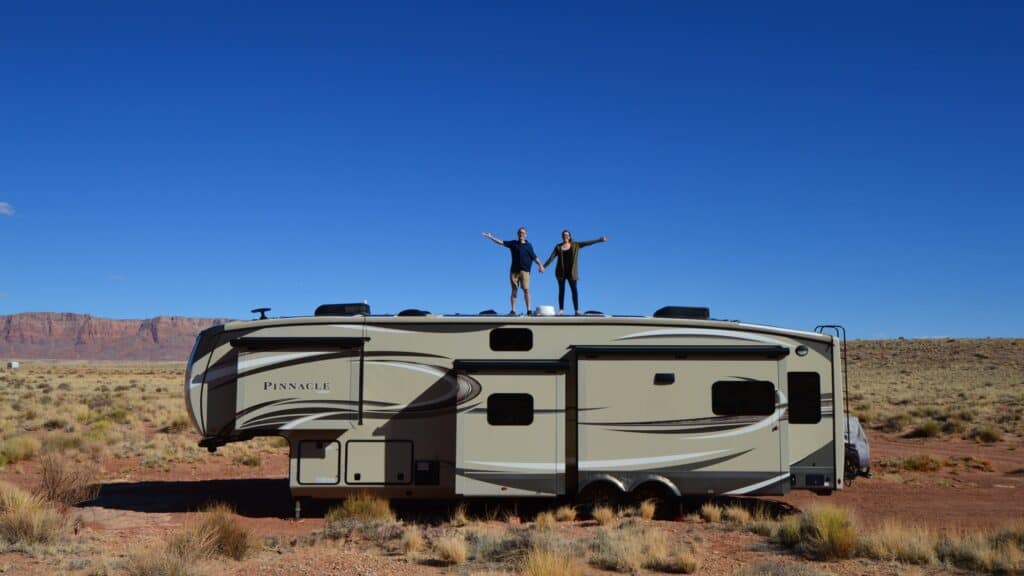 Couple on RV roof while camping in their RV
