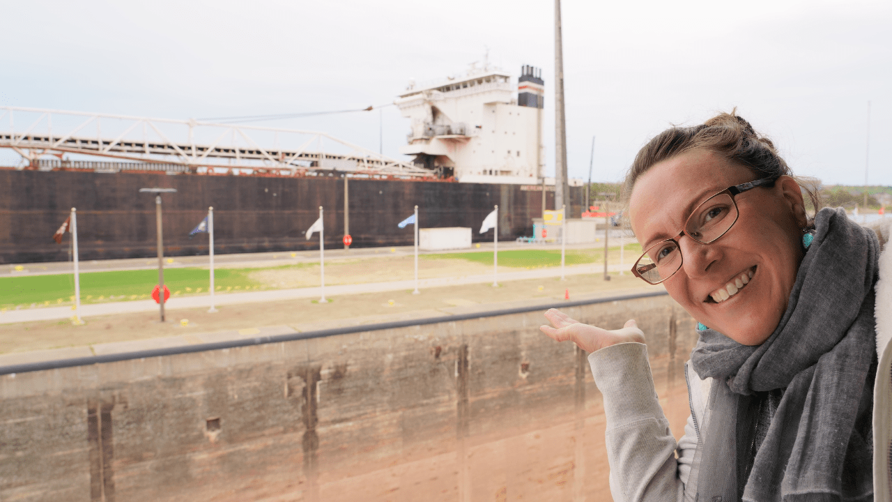 Woman watching a large ship coming through the Soo Locks