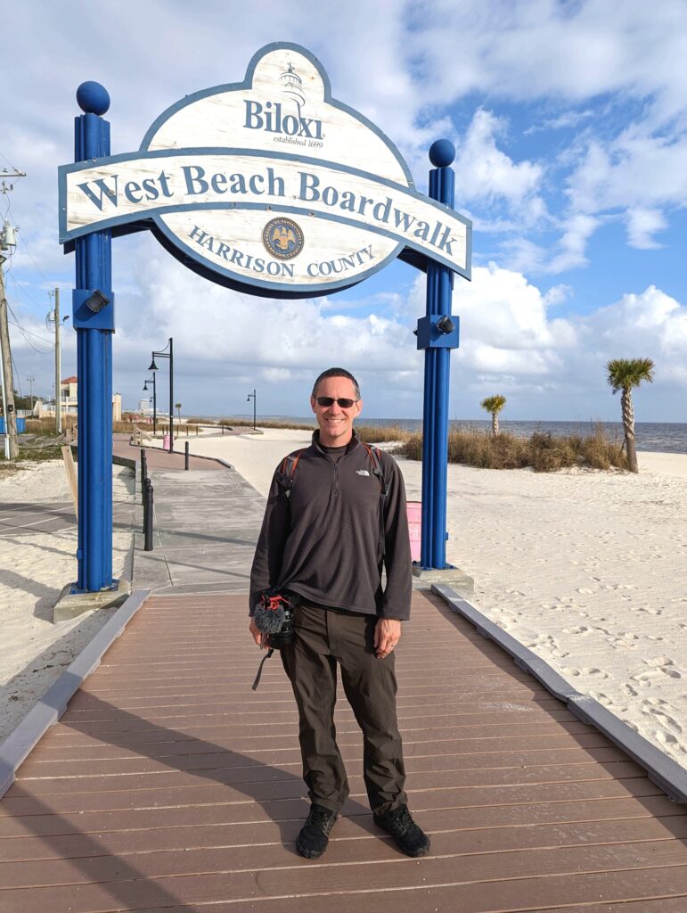 Man wearing Kuhl travel pants for a day of filming on the boardwalk