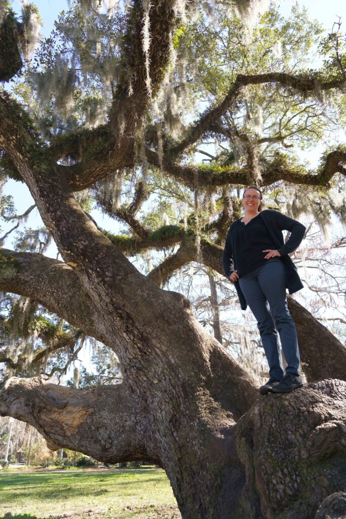 Woman standing in huge oak tree